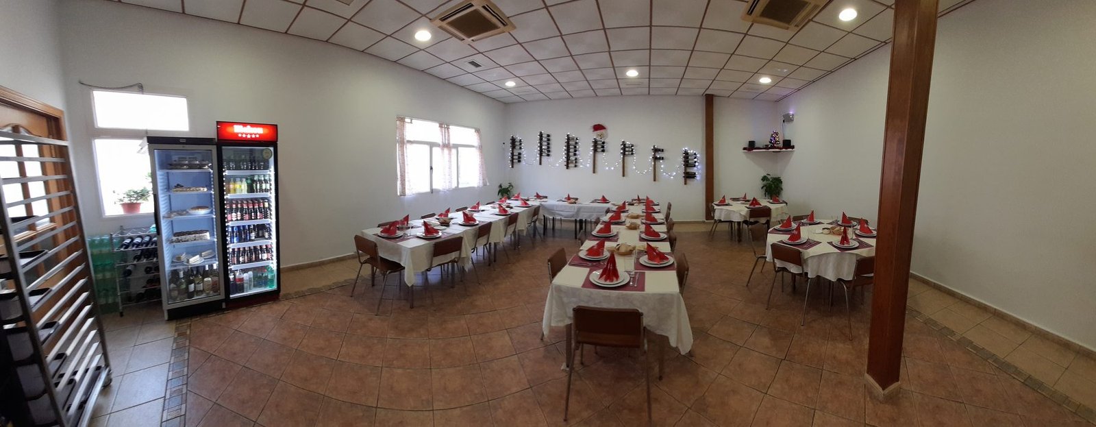 Salón interior de Plato Português preparado para una celebración en grupo, con mesas vestidas de blanco