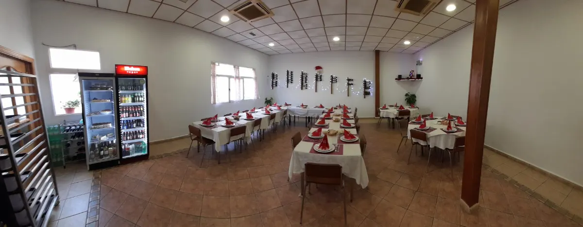 Salón interior de Plato Português preparado para una celebración en grupo, con mesas vestidas de blanco